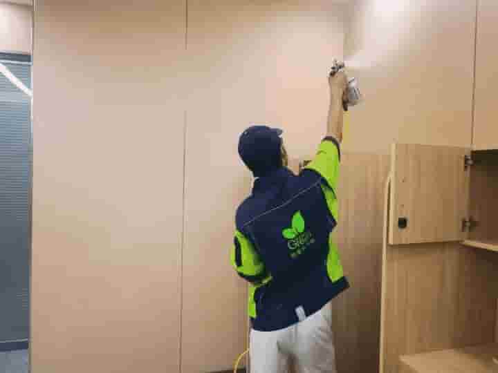 格瑞乐团队成员在卧室里，对照户型图，用记号笔在墙面上标记出甲醛检测的具体点位。