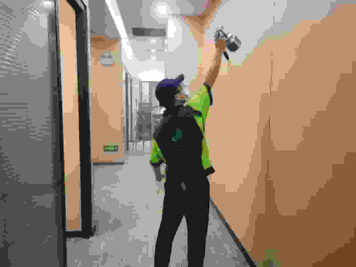 检测人员在书房，将检测仪器的采样管伸到书架旁，设定好检测时间，准备采集空气样本。